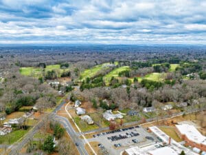 An aerial of Longmeadow country club in late fall deciduous trees green grass buildings